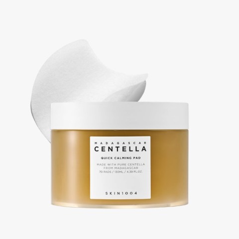 jar of Madagasy Centella Quick Calming Pad with a white lid and a large cotton pad leaning behind it