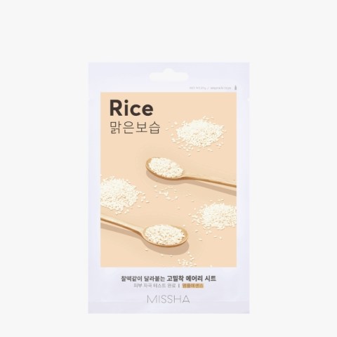 Missha Rice facial sheet mask packaging with beige label and scattered rice grains on spoons against a light background.