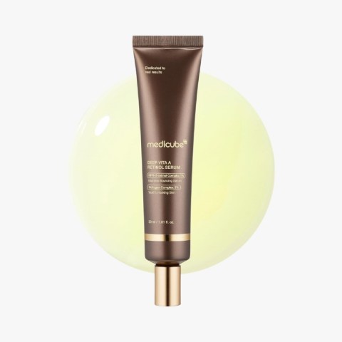 Brown tube of Medicube Deep Vita A Retinol Serum with gold cap, set against a pale yellow circular backdrop, vertical orientation.