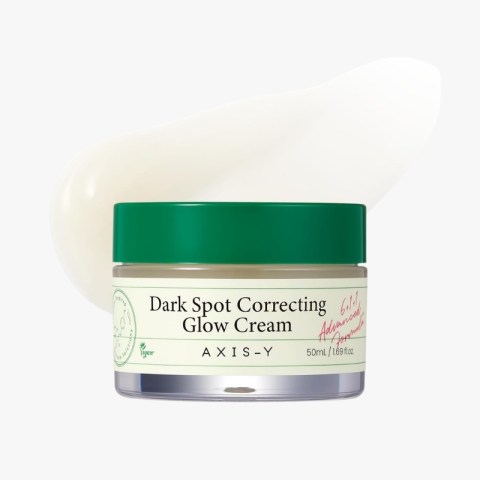 Dark Spot Correcting Glow Cream by Axis-Y in a clear jar with a green lid and cream smear behind it on a white background (skincare product).