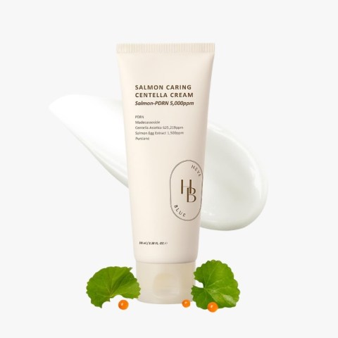 Cream tube labeled 'Salmon Caring Centella Cream' with white cream smear in background, decorative orange berries and green leaves at base.