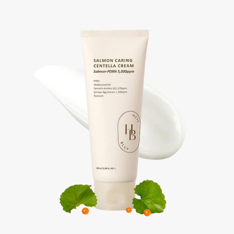 Cream tube labeled 'Salmon Caring Centella Cream' with white cream smear in background, decorative orange berries and green leaves at base.