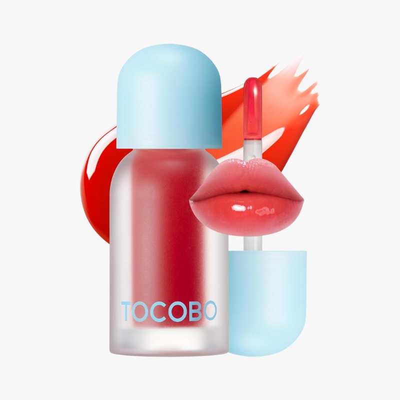 Tocobo lipstick bottle with a blue cap, red liquid inside, and glossy pink lips against a light background.",