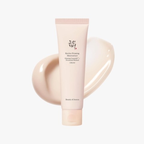 Facial moisturizer tube labeled 'Revive Firming Moisturizer' with a pale pink background and cream swatch behind.