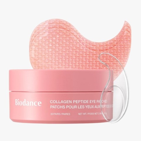 Pink Biodance collagen peptide eye patches in a round pink jar with one patch resting on top.